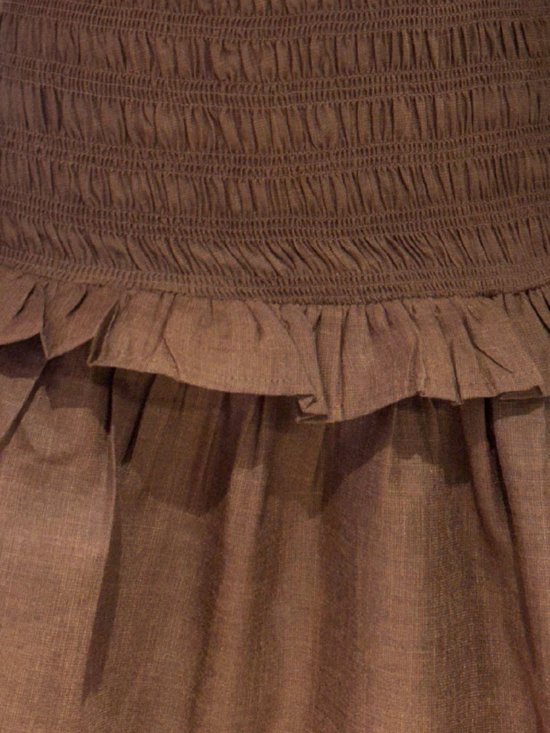 Brown smocked mini dress with a ruffle hem.