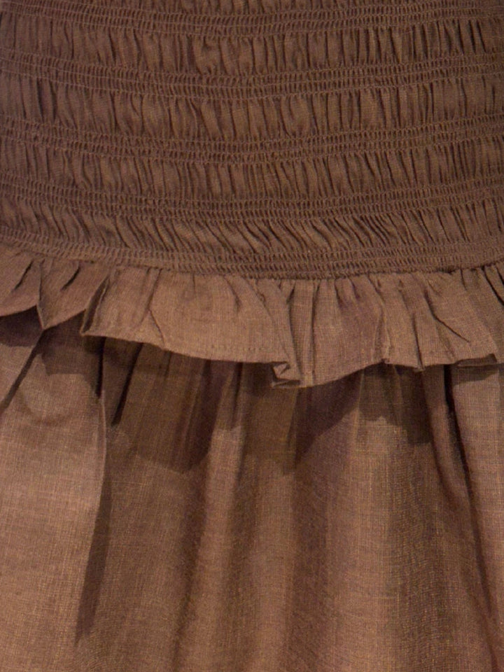 Brown smocked mini dress with a ruffle hem.